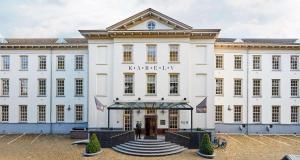 a large white building with a person standing outside at Grand Hotel Karel V in Utrecht