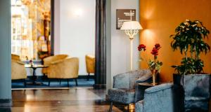 een lobby met 2 stoelen en een tafel met bloemen bij Grand Hotel Karel V in Utrecht