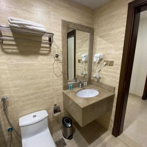 W łazience znajduje się umywalka, toaleta i lustro. w obiekcie Mabeet Al-Khobar w mieście Al-Chubar