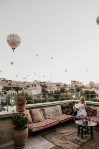 a little girl sitting on a couch on a balcony at Heybe Hotel & Spa in Goreme