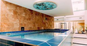 a large swimming pool in a building with a ceiling at Grand Hotel Karel V, WorldHotels Luxury in Utrecht