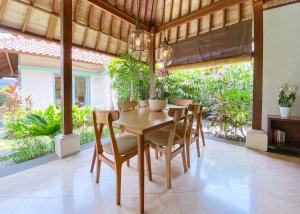 a dining room with a wooden table and chairs at Villa Savannah in Canggu