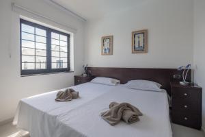 ein Schlafzimmer mit einem Bett mit zwei Handtüchern darauf in der Unterkunft 3BR House - Parking - Pool - 15 min walk to Beach in Mogán