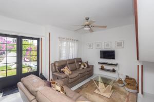 ein Wohnzimmer mit einer Couch und einem Deckenventilator in der Unterkunft 3BR House - Parking - Pool - 15 min walk to Beach in Mogán