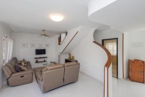 ein Wohnzimmer mit einem Sofa, einem Stuhl und einer Treppe in der Unterkunft 3BR House - Parking - Pool - 15 min walk to Beach in Mogán