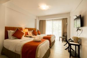 Habitación de hotel con 2 camas y TV en White House Beach Resort, en Boracay