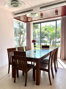 a dining room with a table and chairs and a window at D6 Aria Resort in Vung Tau