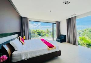- une chambre avec un lit et une grande fenêtre dans l'établissement D6 Aria Resort, à Vung Tau