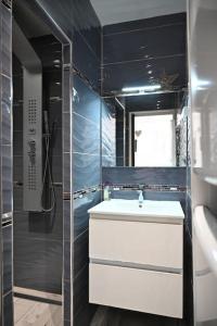 un bagno con lavandino e doccia in vetro di Studio Cosy " La Tarente Dorée " a Fréjus