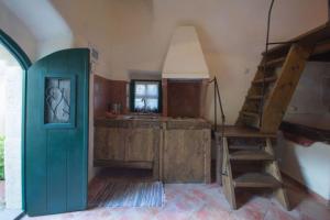 een keuken met een groene deur en een trap in een kamer bij Abramis Rooms in Mitáta
