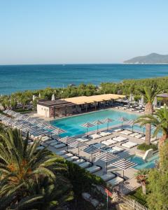 een uitzicht over een zwembad met ligstoelen en de oceaan bij Doryssa Seaside Resort in Pythagoreio