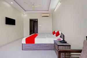 a bedroom with a bed and a television in it at SPOT ON 81091 Gmall in Haldwāni