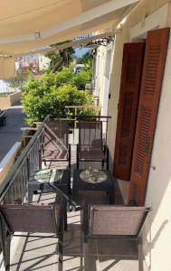 a group of chairs and tables on a balcony at La Bandolaise à Perdika in Perdika