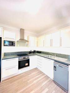 ダブリンにあるLuxury Apartment Top Location RDS, Aviva 5 min walkのキッチン(白いキャビネット、白い電化製品付)