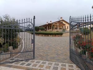 a gate to a driveway with a house in the background at La Collina dei Ciliegi in San Mauro di Saline