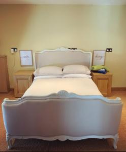 1 cama blanca grande en una habitación con 2 mesas en Self contained 1 bedroomed Annex with street parking, en Ilkeston