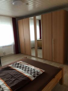 een slaapkamer met een bed en een grote spiegel bij Ferienwohnungjahrsfeld in Straßenhaus