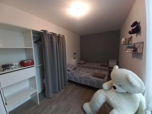 ein Schlafzimmer mit einem großen weißen Teddybär auf dem Boden in der Unterkunft Apart sud vendee, zen et confort centre bourg in Saint-Hilaire-des-Loges