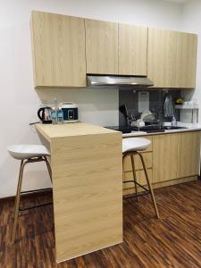 a kitchen with wooden cabinets and a counter with two stools at K Avenue with Peak Escapes in Donggongon