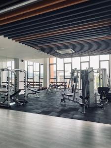 a gym with treadmills and machines in a room with windows at K Avenue with Peak Escapes in Donggongon