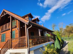 uma cabana de madeira com um alpendre envolvente em Winery & Rural Holiday Home Hren Hiža - Sveti Martin na Muri em Gornji Koncovčak