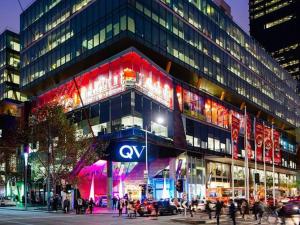 un grande edificio con persone di fronte ad esso di notte di Compact 2B1B Centre of CBD near QV Shopping Centre a Melbourne
