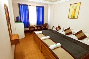 een slaapkamer met een groot bed en blauwe gordijnen bij Retreat Hotel Samden, Darjeeling in Darjeeling
