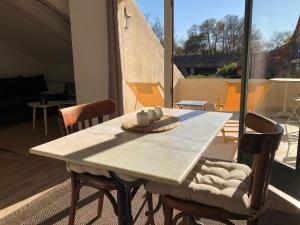 einen Tisch und Stühle in einem Zimmer mit Fenster in der Unterkunft Terrasse avec vue Domaine Viticole in Sallèles-dʼAude