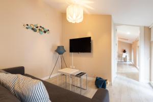 sala de estar con sofá y TV en la pared en INSIDEHOME Apartments - La Casita de Montse en Palencia