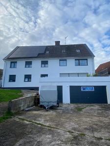 uma casa branca com garagem e um edifício em Apartments Feniks em Blomberg