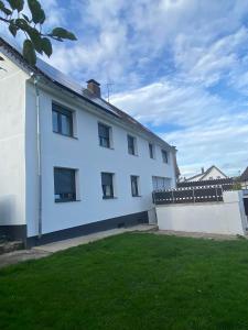 Biały dom z ogrodzeniem i ogródkiem w obiekcie Apartments Feniks w mieście Blomberg