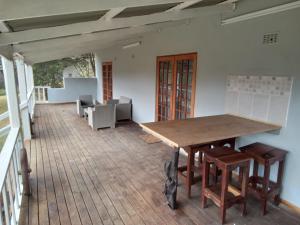 a dining room with a wooden table and chairs at Valley Of The Rainbow Estate in Dullstroom