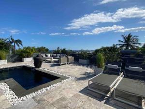 a patio with chairs and a swimming pool at Villa L’Eden Zen face à l océan in Saint-Pierre