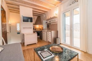 a large kitchen with a table and a large window at Panormos Art Villas & Suites in Panormos