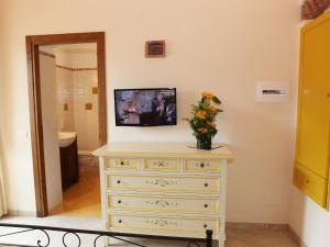 a dresser with a vase of flowers on top of it at Villa Alba in Marciana Marina