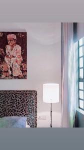 a bedroom with a bed and a lamp and a picture at Killi Bohemian Luxury in Moshi