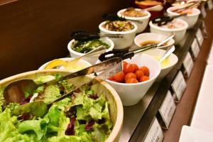 a buffet filled with bowls of salad and vegetables at Bayside Hotel Azur Takeshiba in Tokyo