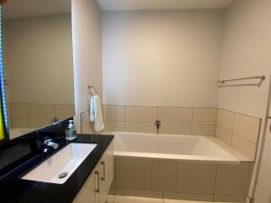 Easy Stay - The Median Rosebank في جوهانسبرغ: حمام مع حوض استحمام ومغسلة