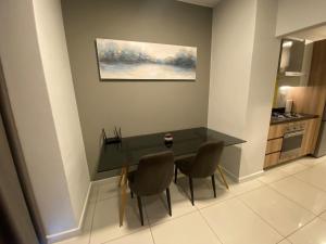 a dining room table with two chairs and a painting on the wall at Easy Stay - The Median Rosebank in Johannesburg