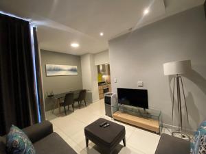 sala de estar con sofá y mesa en Easy Stay - The Median Rosebank en Johannesburgo