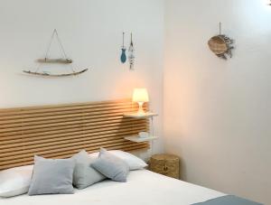 1 dormitorio con 1 cama con cabecero de madera en Piccolo Loft Sabbia e Sassi - Incantevole Loft sulla Costa dei Trabocchi, en San Vito Chietino