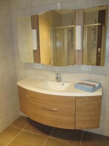 ein Bad mit einem Waschbecken und einem Spiegel in der Unterkunft Haus Alpin Apartments in Pettneu am Arlberg