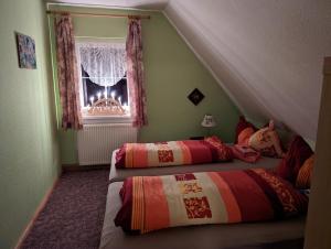 a bedroom with two beds in front of a window at Ferienhaus Ferien am Waldrand in Kurort Altenberg
