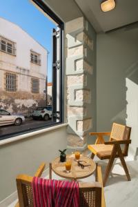 een patio met een tafel en stoelen en een raam bij The Alma City Hotel in Chania