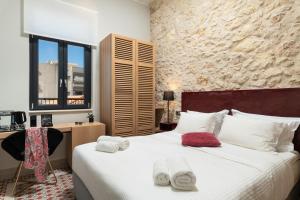 a bedroom with a large bed with towels on it at The Alma City Hotel in Chania Town
