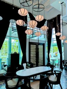 a dining room with tables and chairs and umbrellas at Grand Supicha City Hotel - SHA Plus in Phuket Town