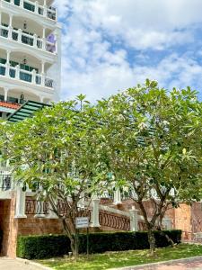a building with two trees in front of it at Grand Supicha City Hotel - SHA Plus in Phuket Town