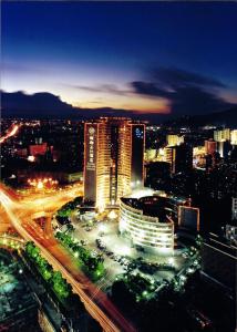 a city lit up at night with traffic at Yindo Jasper Hotel Zhuhai in Zhuhai