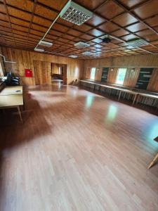een grote kamer met een houten dansvloer bij OWR Relax - Hostel położony blisko atrakcji turystycznych in Szczytna
