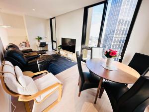 a living room with a table and a couch at Melbourne CBD Empire Apartment in Melbourne